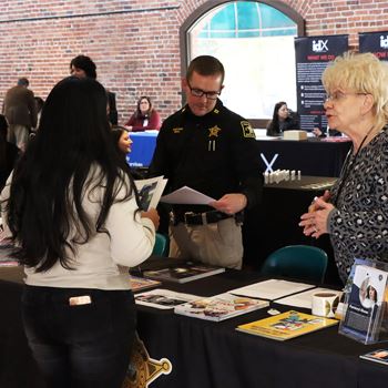 Sheriff's Office employees interact with an interested guest at the Job Fair