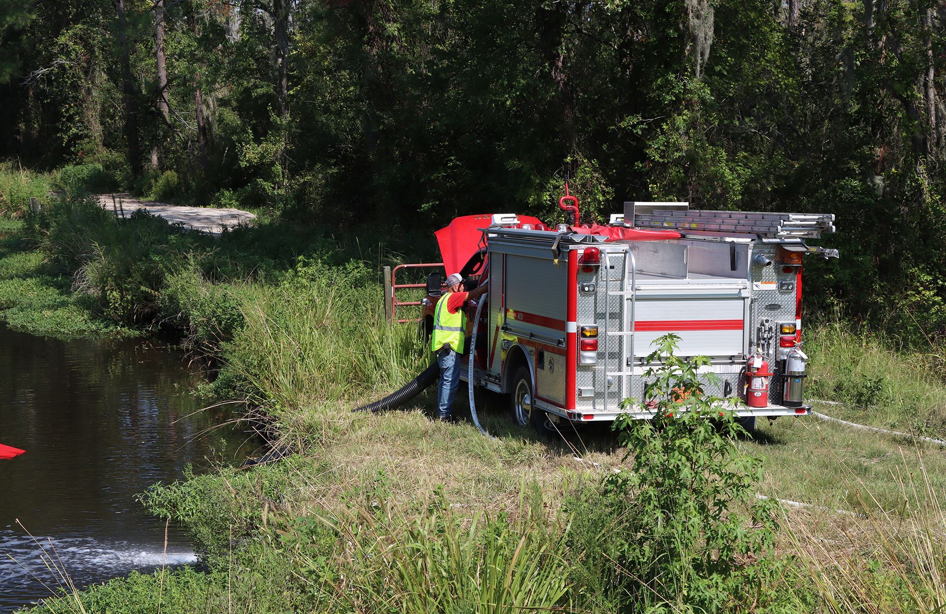 A first responder works at a pump site during the water shuttle operation